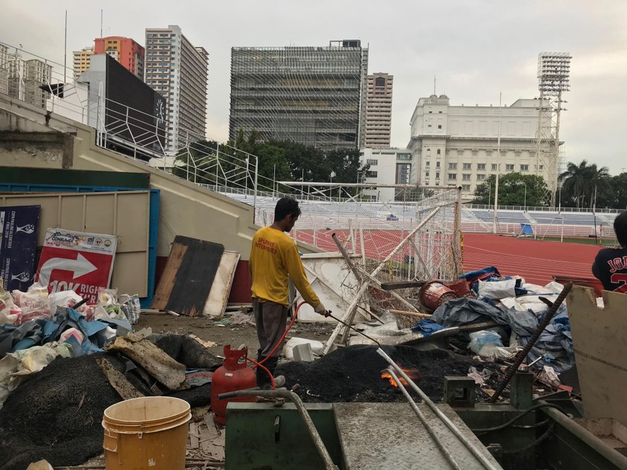 Bên ngoài sân Rizal Memorial vẫn căng bạt thi công (ảnh nhỏ) trong khi bên trong vẫn ngổn ngang vật liệu (ảnh to). Ảnh V.P