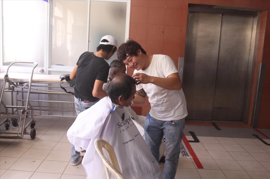 Anh Phạm Văn Lành cùng các cộng sự đang cắt tóc cho các bệnh nhân tại khoa Nội thần kinh - Bệnh viện Đà Nẵng. Ảnh: Giang Thanh