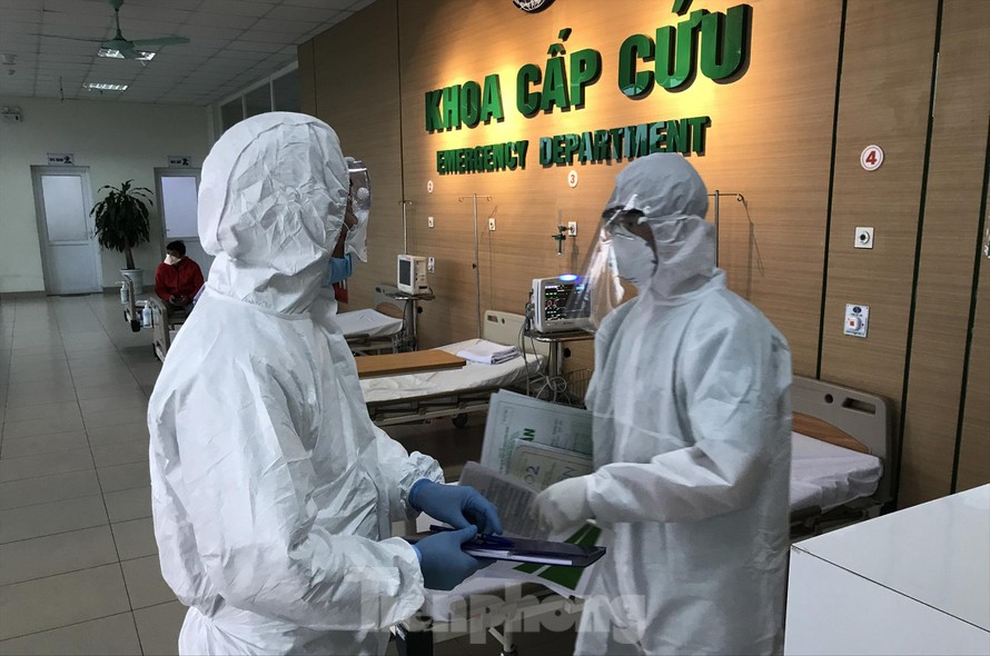 Điều dưỡng Trường (phải) đang trao đổi với đồng nghiệp về bệnh nhân nghi nhiễm
