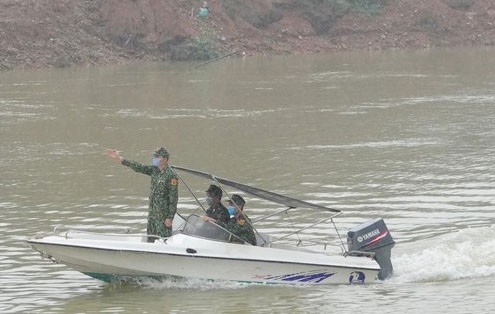 Cán bộ Đồn Biên phòng Pò Hèn và học viên tăng cường lên biên giới tuần tra chống dịch trên sông Ka Long, đoạn gần mốc 1352. ẢNH: NGUYỄN MINH