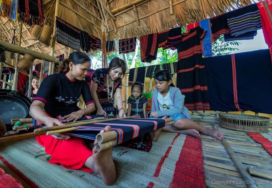 Trần Thị Một (thứ 2 từ trái sang) hướng dẫn các bạn trẻ cách dệt thổ cẩm truyền thống của người Cơ Tu. Ảnh: NVCC
