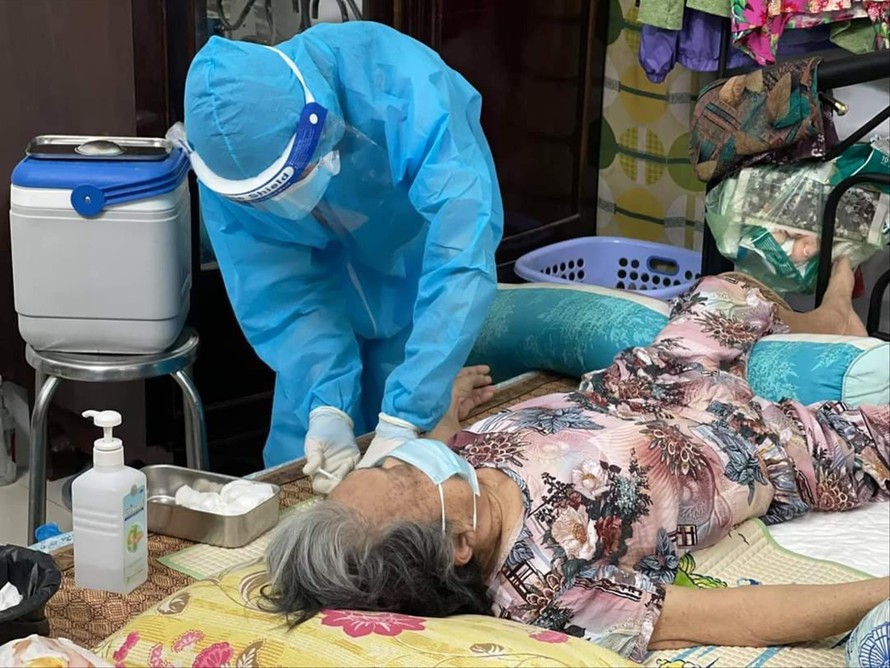 Đội ngũ y bác sĩ đến tận nhà tiêm vắc-xin cho người già có bệnh nền để tạo miễn dịch trong cộng đồng Ảnh: L.N 