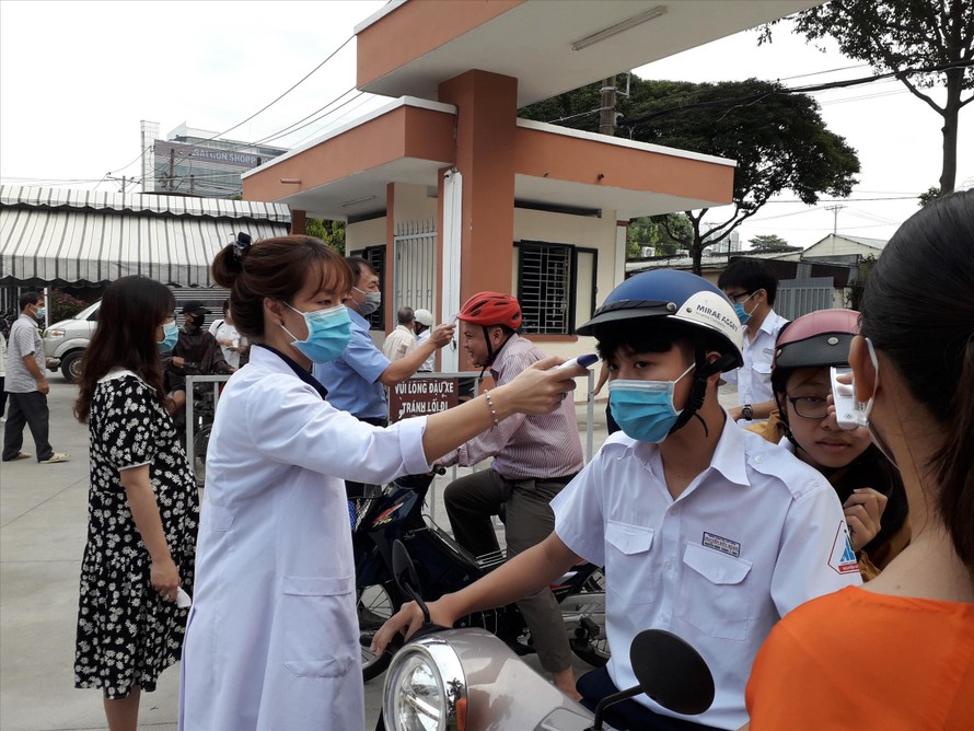 Các trường học ở TPHCM duy trì biện pháp đo thân nhiệt cho học sinh trước khi vào lớp. Ảnh chụp tại Trường THPT chuyên Nguyễn Hữu Huân (TP Thủ Đức). Ảnh: Huy Thịnh