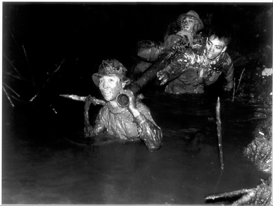 Quân Giải phóng khiêng súng cối qua đầm lầy để tấn công đồn Cái Keo, Cà Mau, năm 1963 Ảnh: Trần Bỉnh Khuôl 