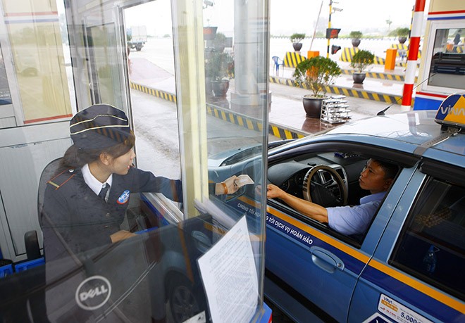 Khách hàng trả tiền tại trạm thu phí BOT Pháp Vân Cầu Giẽ. ẢNH: MINH CHÂU