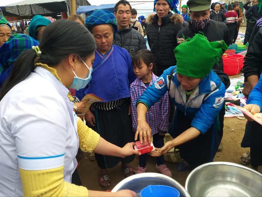 Huyện Ðoàn Xín Mần (Hà Giang) tuyên truyền, hướng dẫn bà con dân tộc thiểu số rửa tay bằng xà phòng đúng cách tại khu chợ phiên. Ảnh: PV ​