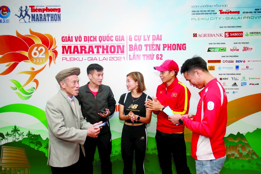 Các VĐV điền kinh hàng đầu Việt Nam trò chuyện với lão tướng điền kinh Bùi Lương (bìa trái) trước buổi họp báo giới thiệu giải Tiền Phong Marathon 2021. Ảnh: Như Ý 