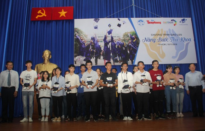 Nhà báo Lê Xuân Sơn (bìa phải) và PGS.TS Nguyễn Minh Hà (bìa trái) trao quà cho các bạn thủ khoa