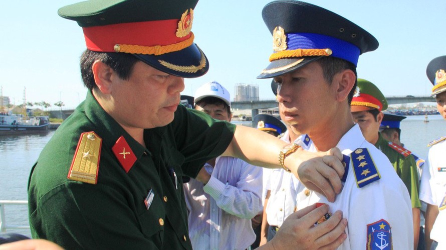 Thiếu tá Hạnh trao Huy hiệu “Tuổi trẻ dũng cảm”, bằng khen của Tổng cục Chính trị cho các cán bộ chiến sĩ Cảnh sát biển.