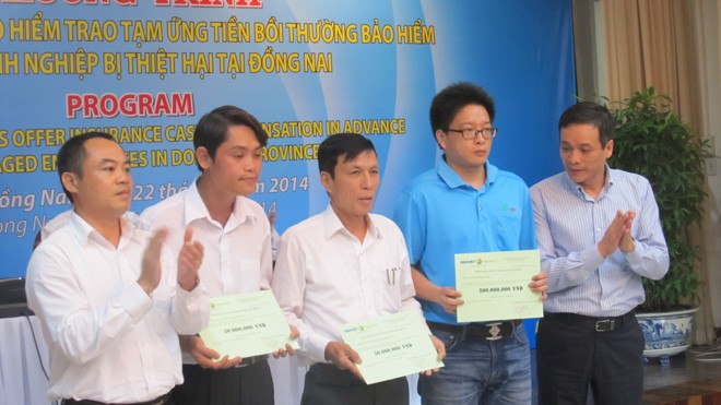 Đại diện Tổng Cty Bảo hiểm Bảo Việt trao tiền tạm ứng bồi thường cho các doanh nghiệp bị thiệt hại