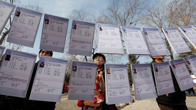 Các bậc phụ huynh lo lắng nhìn vào bản lý lịch của các ứng viên tại một sự kiện mai mối ở Bắc Kinh. Ảnh: Reuters.