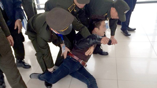 Nam thanh niên gây rối ở sân bay bị lực lượng an ninh khống chế. Ảnh: Otofun