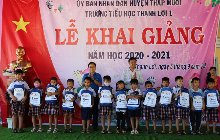 Anh Nguyễn Anh Tuấn (áo xanh) tặng quà cho học sinh Đồng Tháp. ẢNH: TĐ ĐT 