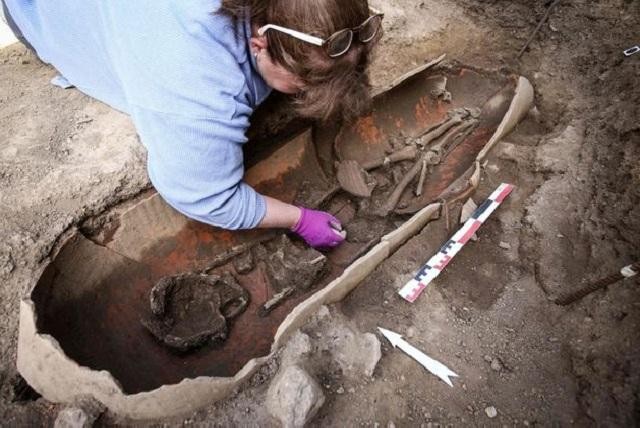 Một nhà khảo cổ học đang làm việc bên bình gốm chứa hài cốt người chết được tìm thấy trên đảo Corsica của Pháp.