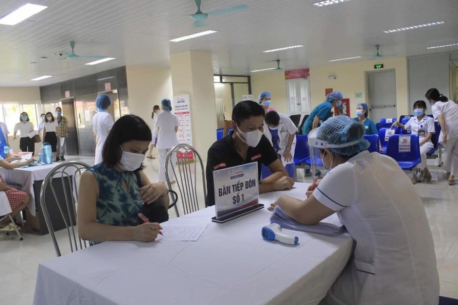 Người dân đăng ký thông tin để làm thủ tục tiêm vắc xin tại Bệnh viện E Trung ương. 