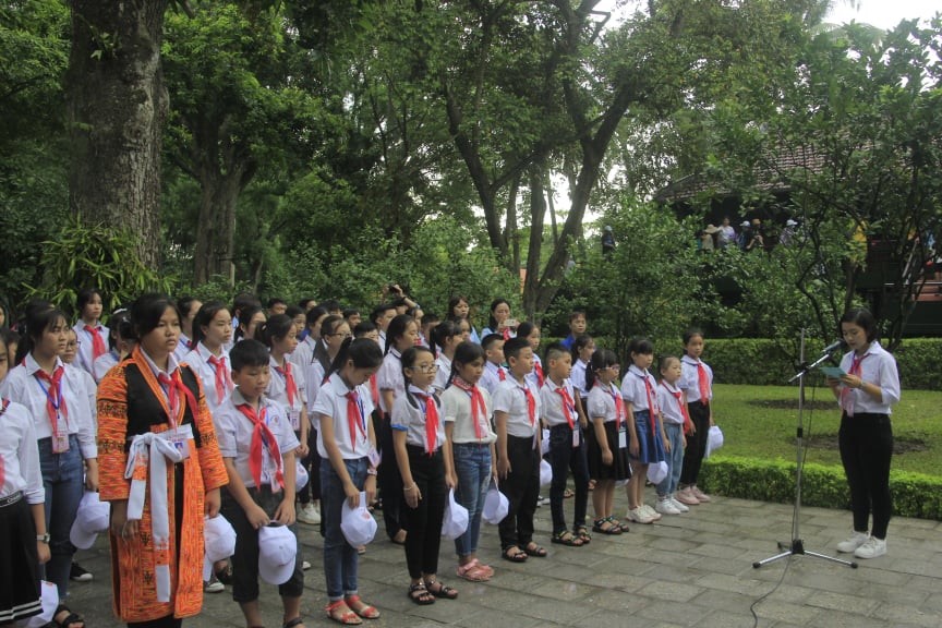 Các đại biểu Cháu ngoan Bác Hồ tỉnh Bắc Giang thực hiện nghi thức báo công dâng Bác. Ảnh Tuyết Mai.