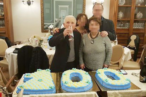 "Bố già" Di Maggio cầm ly uống rượu, chụp ảnh bên chiếc bánh kem hình số 100.