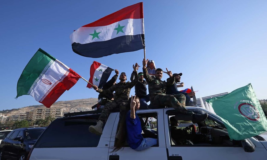 Người dân thủ đô Damascus giơ biểu tượng chiến thắng và vẫy cờ Syria. Ảnh: AP