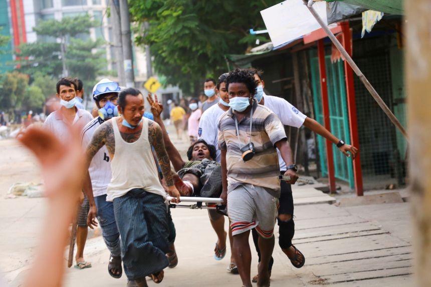 Một người bị thương giơ biểu tượng 3 ngón tay ủng hộ dân chủ. Ảnh: Reuters