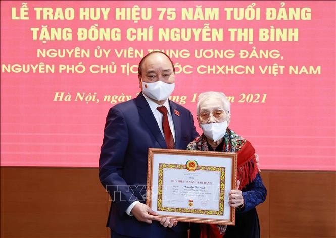 Chủ tịch nước Nguyễn Xuân Phúc trao tặng huy hiệu 75 năm tuổi Đảng cho đồng chí Nguyễn Thị Bình, nguyên Phó Chủ tịch nước CHXHCN Việt Nam.
