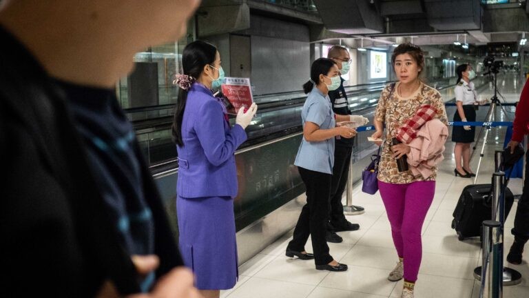Nhân viên y tế tuyên truyền về giám sát dịch bệnh sau khi quét thân nhiệt hành khách tới Bangkok (Thái Lan) từ Vũ Hán (Trung Quốc). Ảnh: Getty.