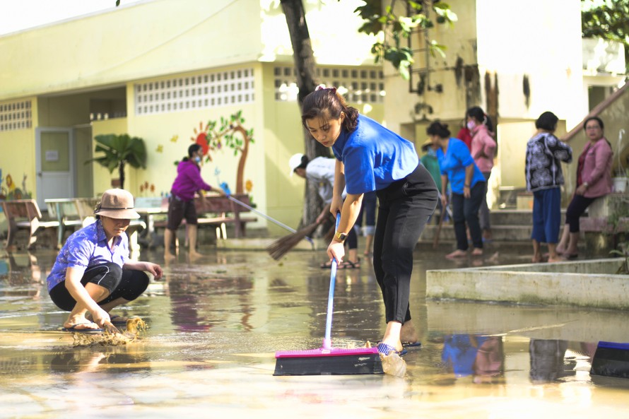 Đoàn viên thanh niên tham gia vệ sinh trường lớp đón học sinh đi lại sau nghỉ bão số 12. Ảnh: Trương Định