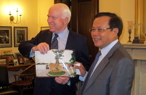 Ông Phạm Quang Nghị trao tặng Thượng nghị sĩ John McCain bức ảnh chụp bia chứng tích bên hồ Trúc Bạch (Ảnh: HNM)