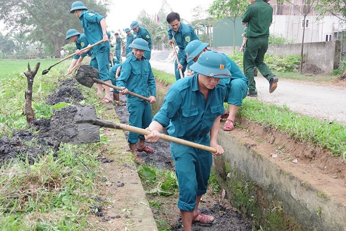 Cán bộ, học viên Trường Quân sự tỉnh Nghệ An đang nạo vét trên tuyến kênh thủy lợi của xã Nghi Kim