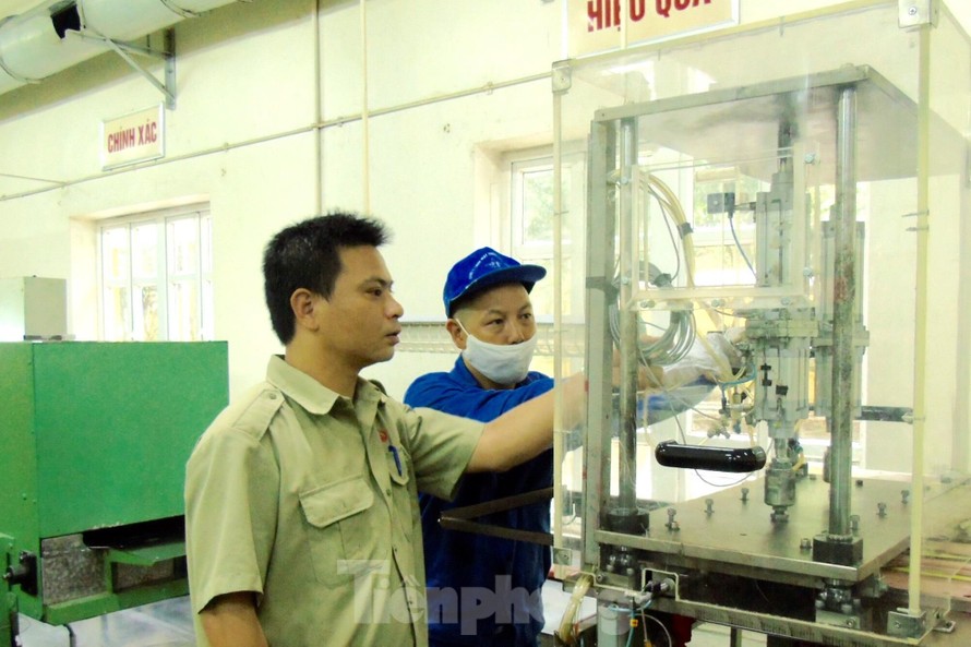 Kỹ sư Nguyễn Tiến Hưng (trái) kiểm tra thiết bị sản xuất sản phẩm quốc phòng tại Nhà máy Z121