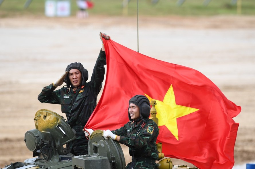 Kíp xe số 1 của đội tuyển Xe tăng Quân đội nhân dân Việt Nam giương cao cờ Tổ quốc sau khi hoàn thành bài thi, chiều 24/8. Ảnh: QĐND