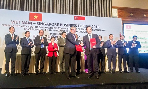 Đại diện Vietcombank, Ông Phạm Quang Dũng – Tổng Giám đốc (hàng đầu, bên phải) và đại diện SBF, ông Ho Meng Kit – Giám đốc điều hành ký kết thỏa thuận hợp tác giữa hai bên.
