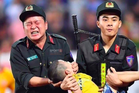 Chiến sỹ cảnh sát cơ động nghiến răng chịu đau để tránh cháu bé cắn vào lưỡi - Ảnh: Hoàng Long