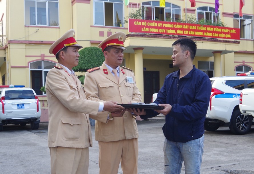 Đại diện Phòng CSGT, Công an tỉnh Hà Nam trao trả tài sản cho người đánh rơi - Ảnh: Công an Hà Nam