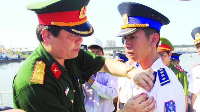 Thiếu tá Thái Đức Hạnh trao Huy hiệu “Tuổi trẻ dũng cảm” cho thuyền trưởng Thượng úy Lê Trung Thành. Ảnh: Nguyễn Huy.