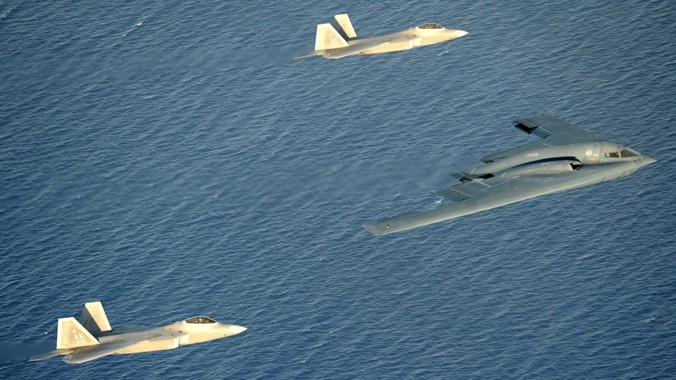 B-2 Spirit được hai chiếc tiêm kích tàng hình F-22 hộ tống tại Guam. Ảnh: US Navy 
