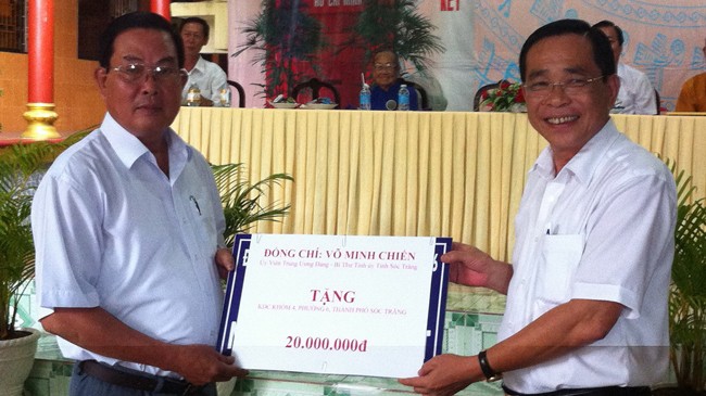 Bí thư Võ Minh Chiến (phải) trao tiền cho đại diện dân khóm 4.