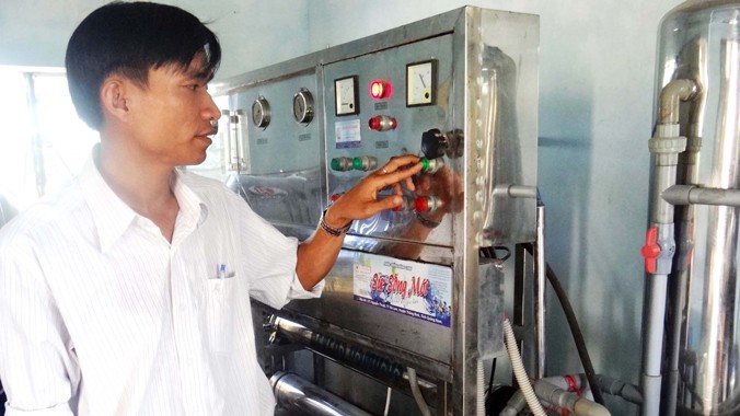 Anh Trần Hữu Tịnh điều khiển hệ thống sản xuất nước uống đóng chai Sức sống mới. Ảnh: Nguyễn Thành.