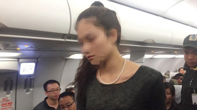 Một trong 2 nữ hành khách đánh nhau trên máy bay được lực lượng an ninh đưa xuống khỏi máy bay Vietnam Airlines. Ảnh: Long Nga.