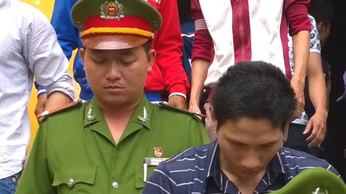 Hưởng xấu hổ cúi mặt khi bị dẫn giải sau phiên tòa.