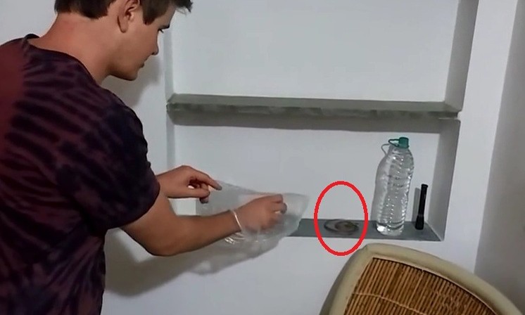 Nam du khách người Anh cầm túi nilon, rón rén bắt con rắn. 