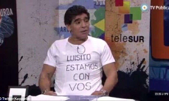 Maradona bày tỏ sự ủng hộ đối với Suarez bằng cách mặc một chiếc áo có dòng chữ: “Luis, chúng tôi ở bên anh”. 