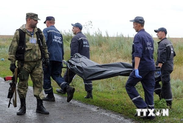 Các nhân viên cứu hộ đưa xác nạn nhân vụ rơi máy bay MH17 rời hiện trường. (Ảnh: AFP/TTXVN)