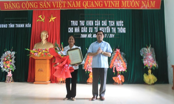 Trao thư khen của Chủ tịch nước Trương Tấn Sang cho cô giáo Nguyễn Thị Thông. Ảnh: Hoàng Lam