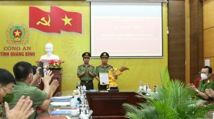 Đại tá Nguyễn Tiến Nam trao quyết định và chúc mừng Đại tá Lê Văn Hóa. Ảnh VGP. 
