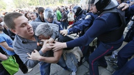 Cảnh sát Ukraina cố gắng tách hai người khi họ đánh nhau tại thành phố Odessa hôm 3/5. Một người ủng hộ chính phủ Ukraina, còn người kia ủng hộ Nga. Ảnh: Reuters