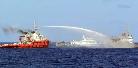 Một tàu Trung Quốc (trái) phun vòi rồng vào tàu Việt Nam (phải) trong khi tàu Canh gác bờ biển Trung Quốc chạy ở bên trên Biển Đông ngày hôm qua (7/5). 