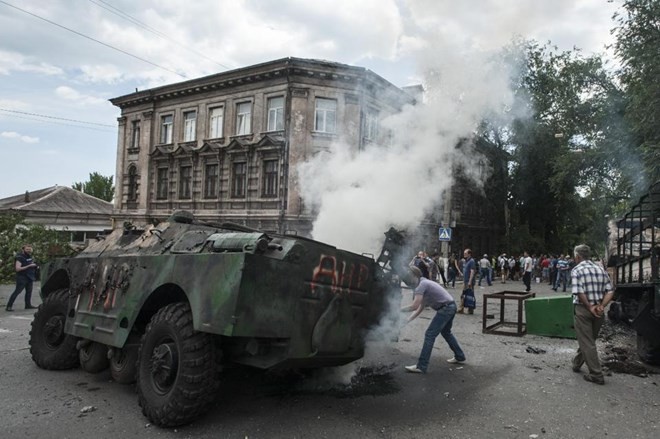 Một chiếc xe quân sự bị đốt sau cuộc đụng độ giữa quân đội Ukraine và phe ly khai ở Mariupol ngày 13/6 (Nguồn: AP)