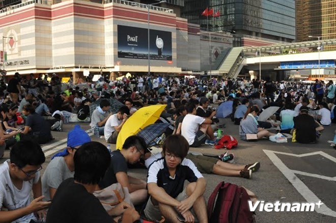 Đám đông biểu tình thấm mệt sau một đêm mệt nhoài quần thảo với cảnh sát. (Ảnh: Tiến Trung/Vietnam+)