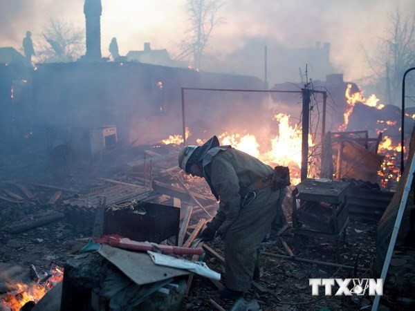 Nhân viên cứu hỏa dập các đám cháy tại một số ngôi nhà bị phá hủy do trúng đạn pháo tại quận Kuibishevskiy, gần sân bay ở Donetsk, miền đông Ukraine ngày 20/11. (Nguồn: AFP/TTXVN)