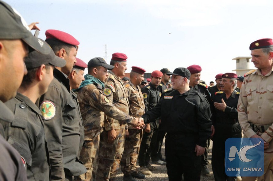 Thủ tướng Haider al-Abadi bắt tay với các sĩ quan quân đội ở Mosul, Iraq, vào ngày 9/7. Ảnh: Tân Hoa Xã